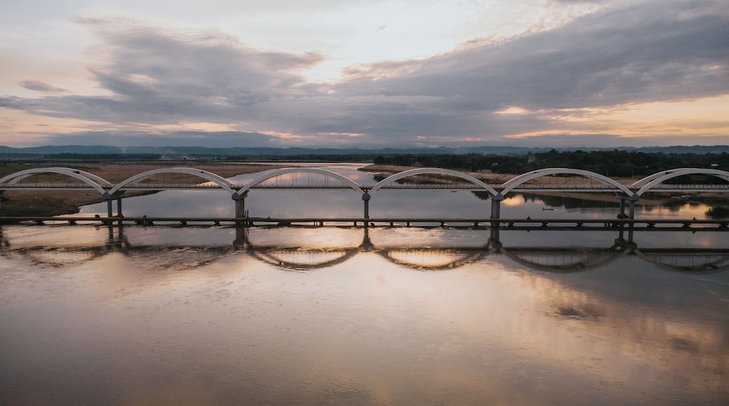 Un pont à arches enjambant une étendue d’eau calme, dans laquelle le ciel se reflète.