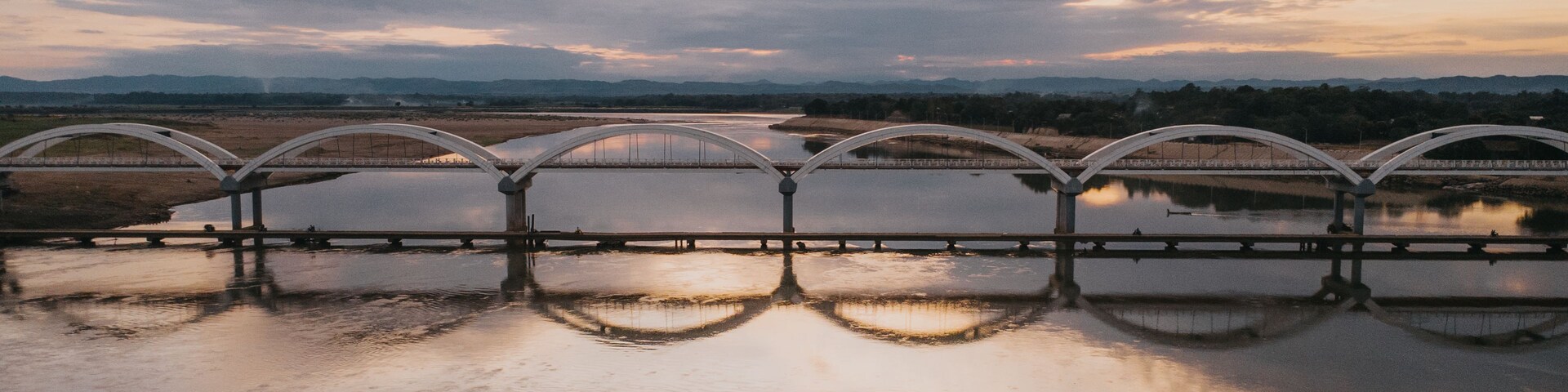 Arches of Twilight: Aerial View of a Multi-Span Bridge Perfectly Reflected on a Calm River at Dusk of Cabagan - Sta. Maria Bridge, Isabela, Philippines