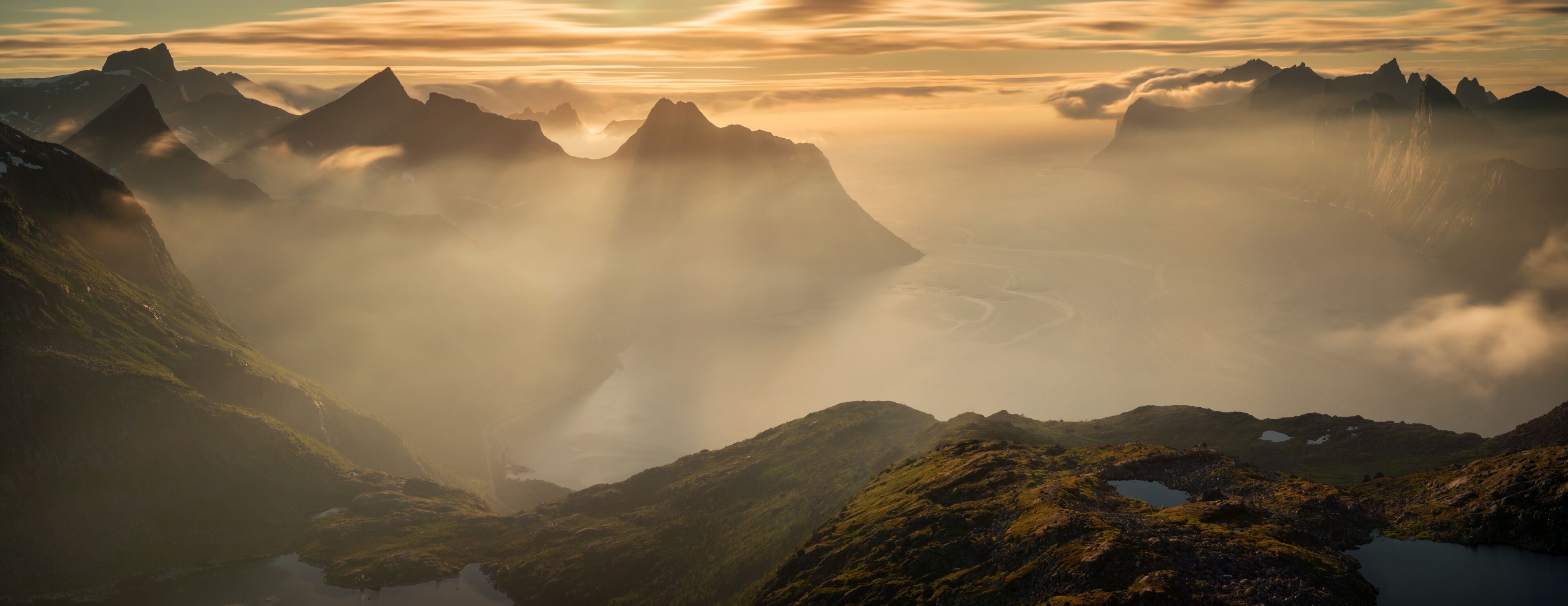 A mountainous landscape with a valley, a lake, and a river.