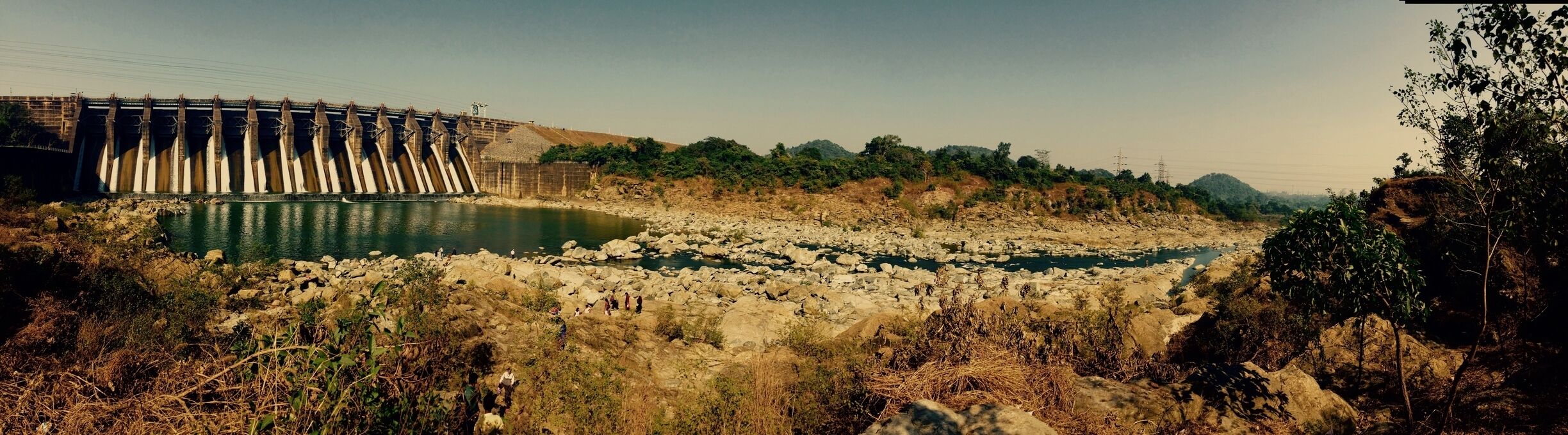 A dam with water flowing through a rocky riverbed.