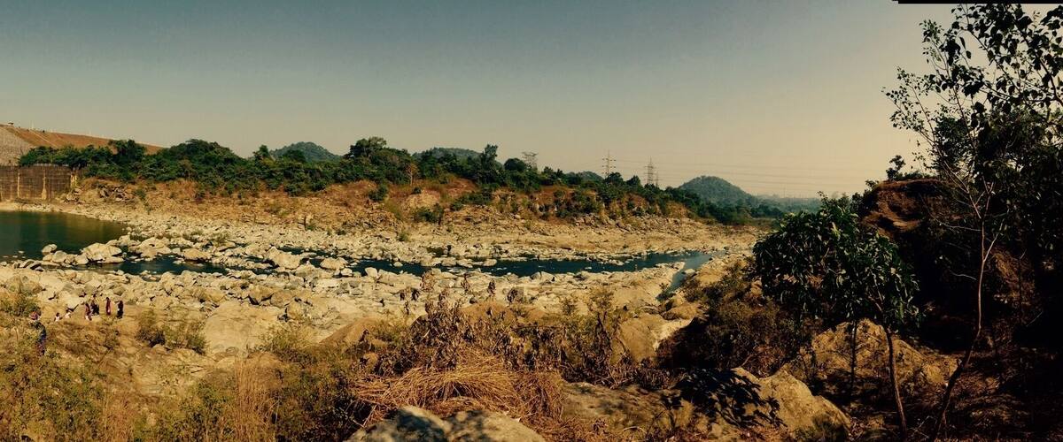 A dam with water flowing through a rocky riverbed.