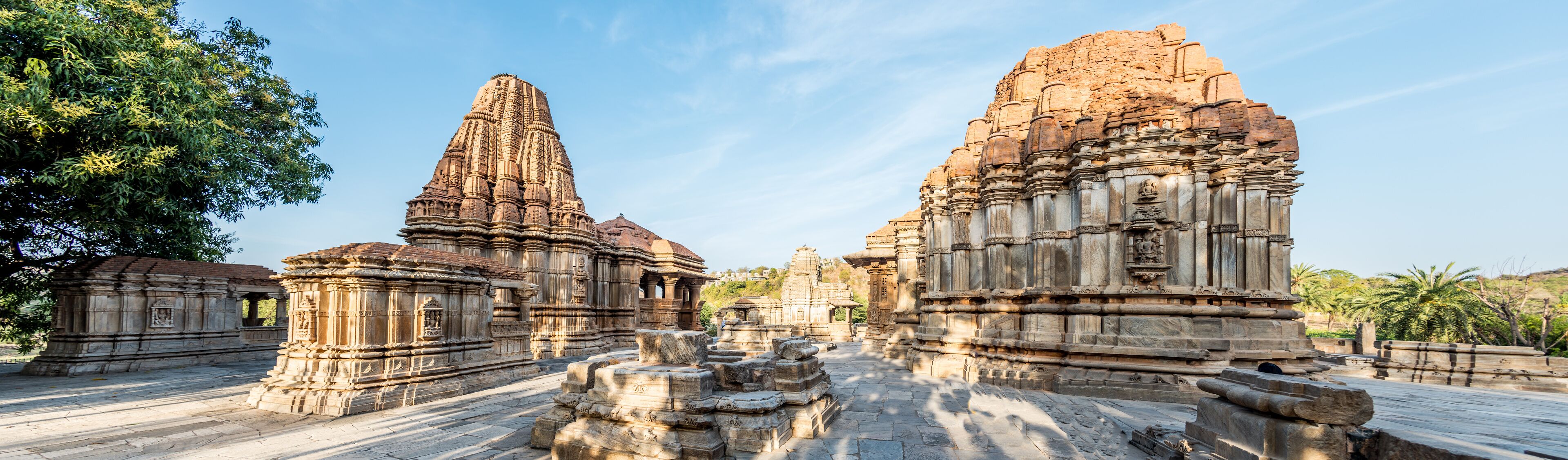 Ancient stone structures with intricate carvings and a clear sky.