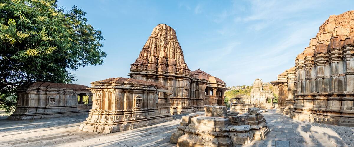 Ancient stone structures with intricate carvings and a clear sky.
