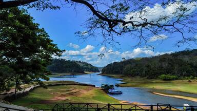 A river with a boat, surrounded by greenery and hills.
