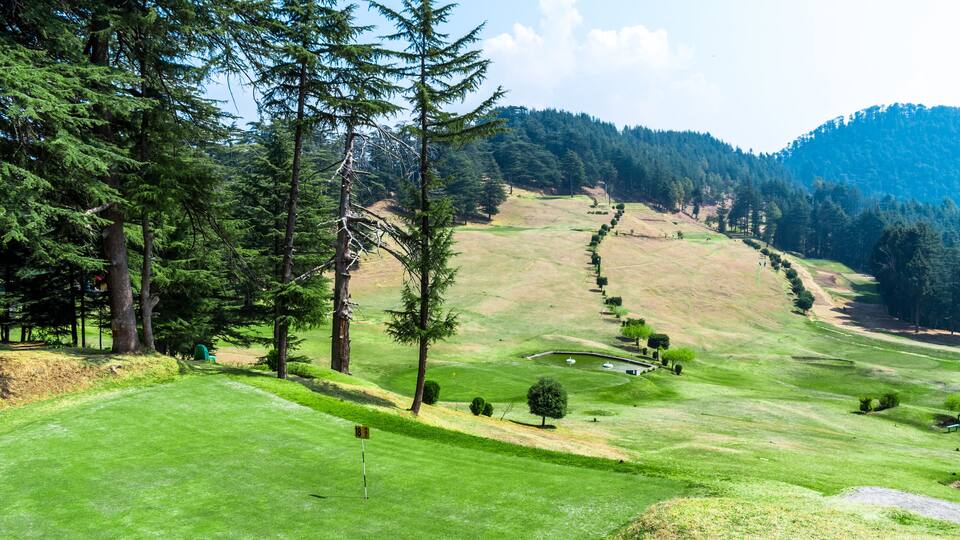 A lush green golf course with a flagstick marked '18' and a well-maintained fairway.