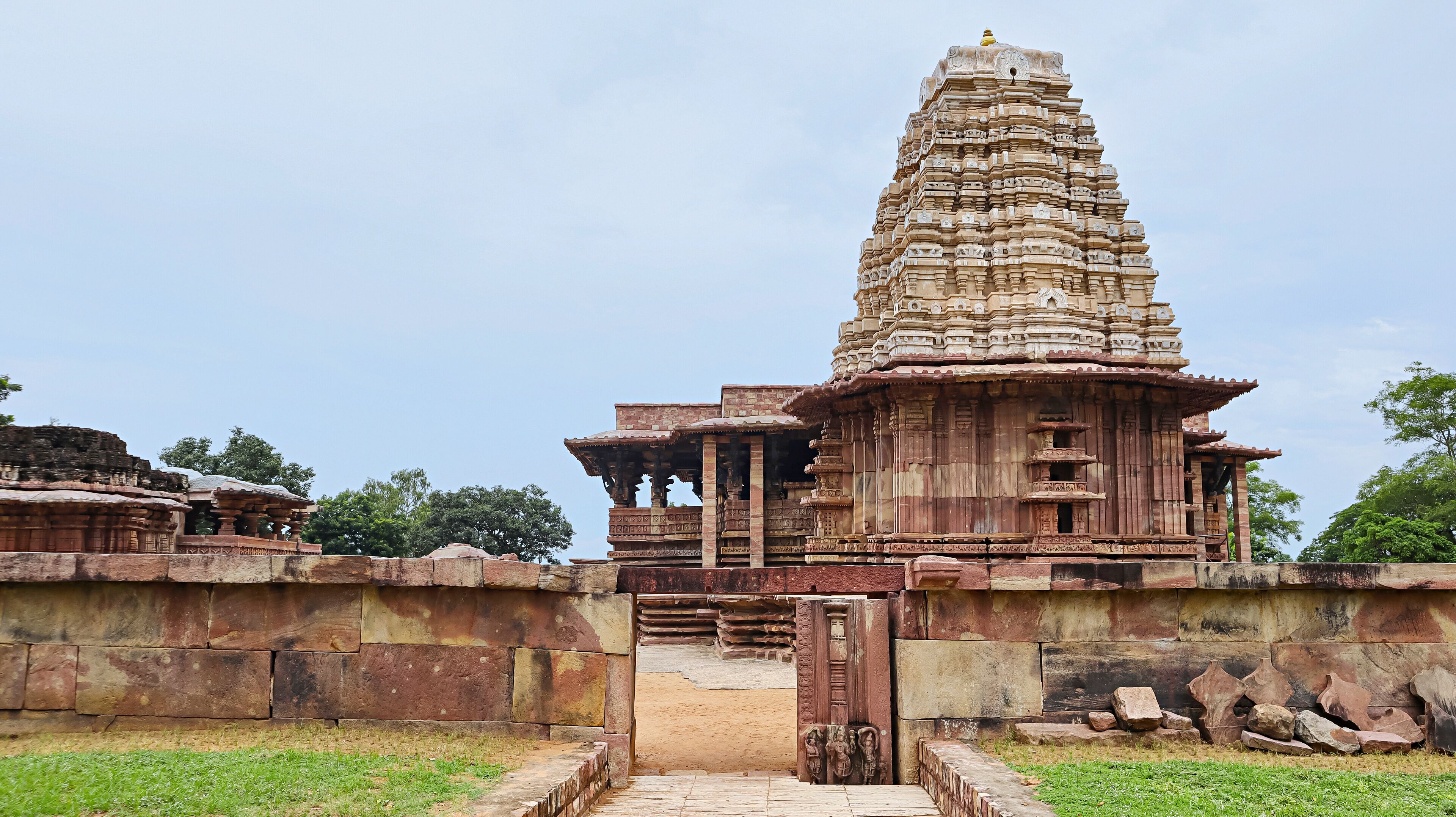 A temple with a tall, intricately carved tower and a gateway.