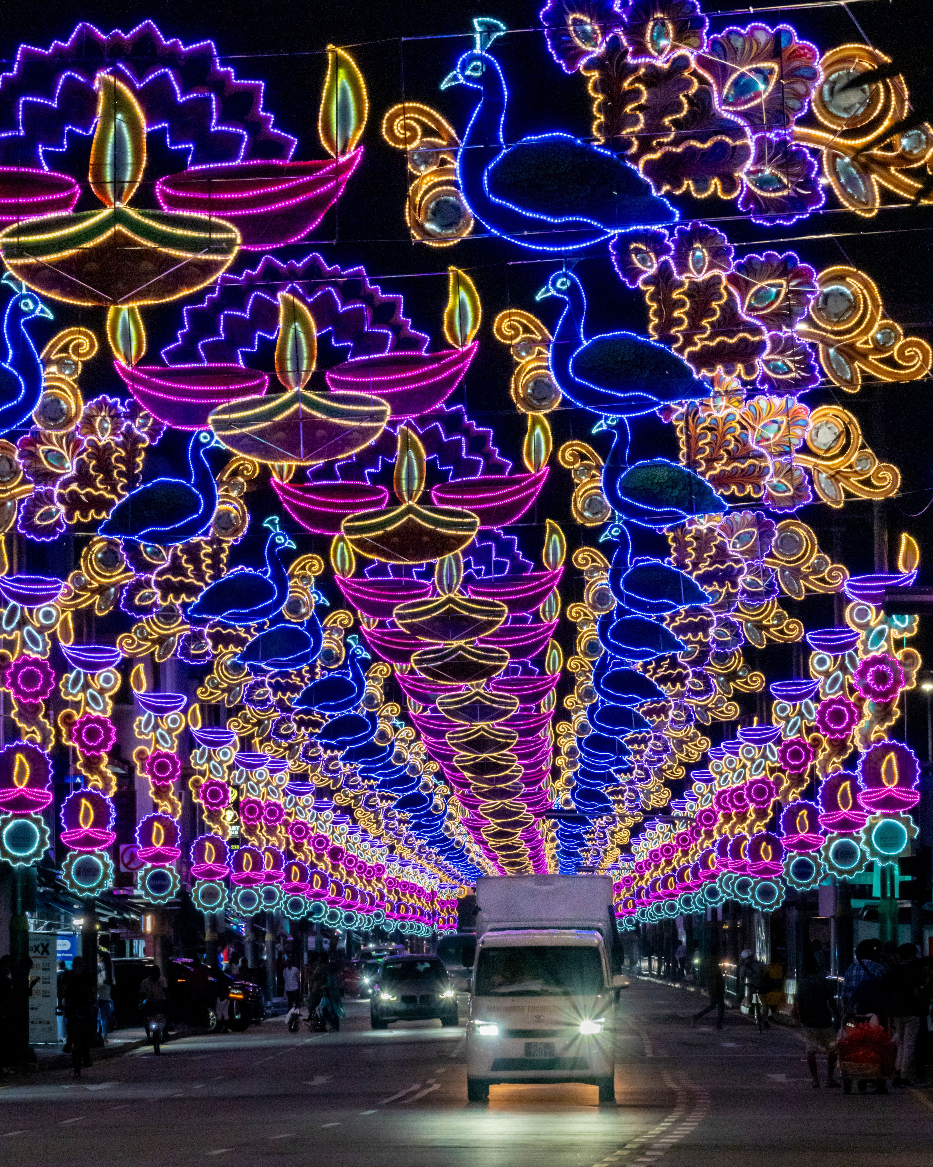 View of colourful Deepavali street lights and decorations with a vibrant crowd, Serangoon Road, Singapore.