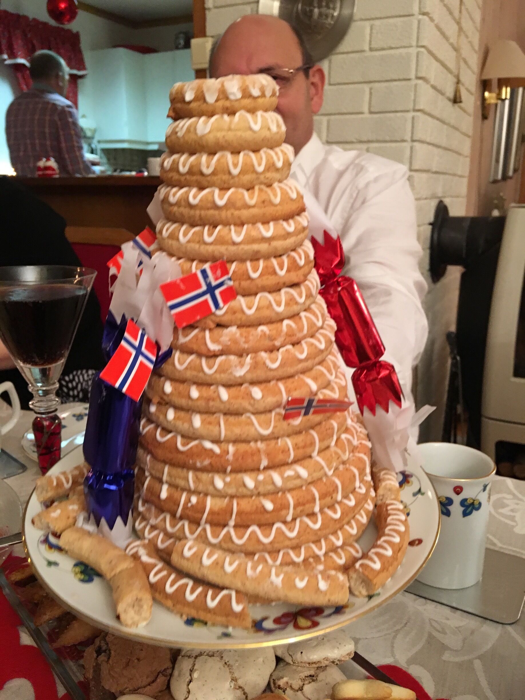 A large gingerbread house with Norwegian flags and a red ribbon.