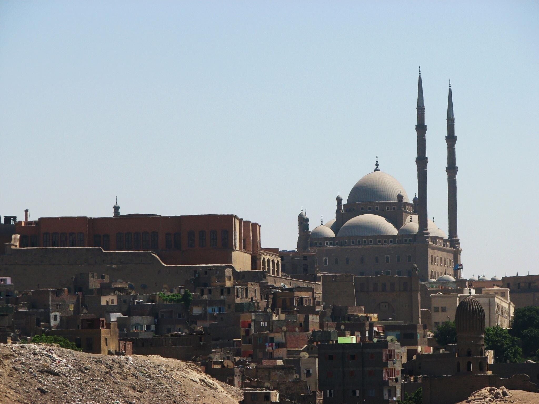 The Citadel of the Mountain (Qal‘at al-Jabal) in Cairo is one of the major works of military architecture of the middle ages. Situated on a spur that was artificially cut out of the Muqattam Hills, the Citadel dominates the city of Cairo and turns its back to the rocky hills and the desert behind. Founded by Salah al-Din al-Ayyubi (Saladin) in 1176 AD, the Citadel was a sign of the coming of a new regime whose roots were foreign and tastes were military. For almost seven centuries (1206-1874 AD), it was the seat of government for the Ayyubids (1171-1250 AD), Mamluks (1250-1516 AD), Ottomans (1516-1798 AD), and the Muhammad ‘Ali Family (1798-1952 AD), as well as a real and symbolic barrier between the rulers and the ruled. During this long period, it was the stage upon which the history of Egypt was played out.