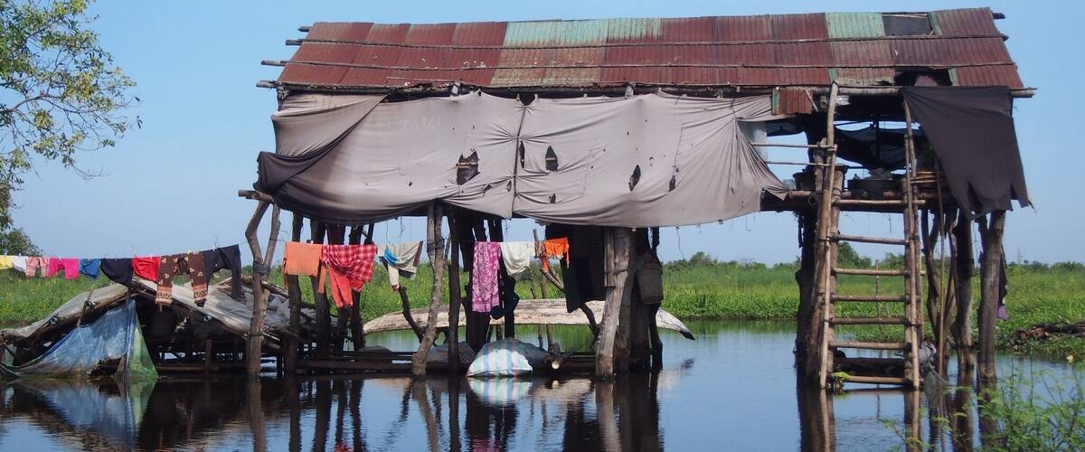 A floating house with a makeshift roof and clothes hanging on lines.