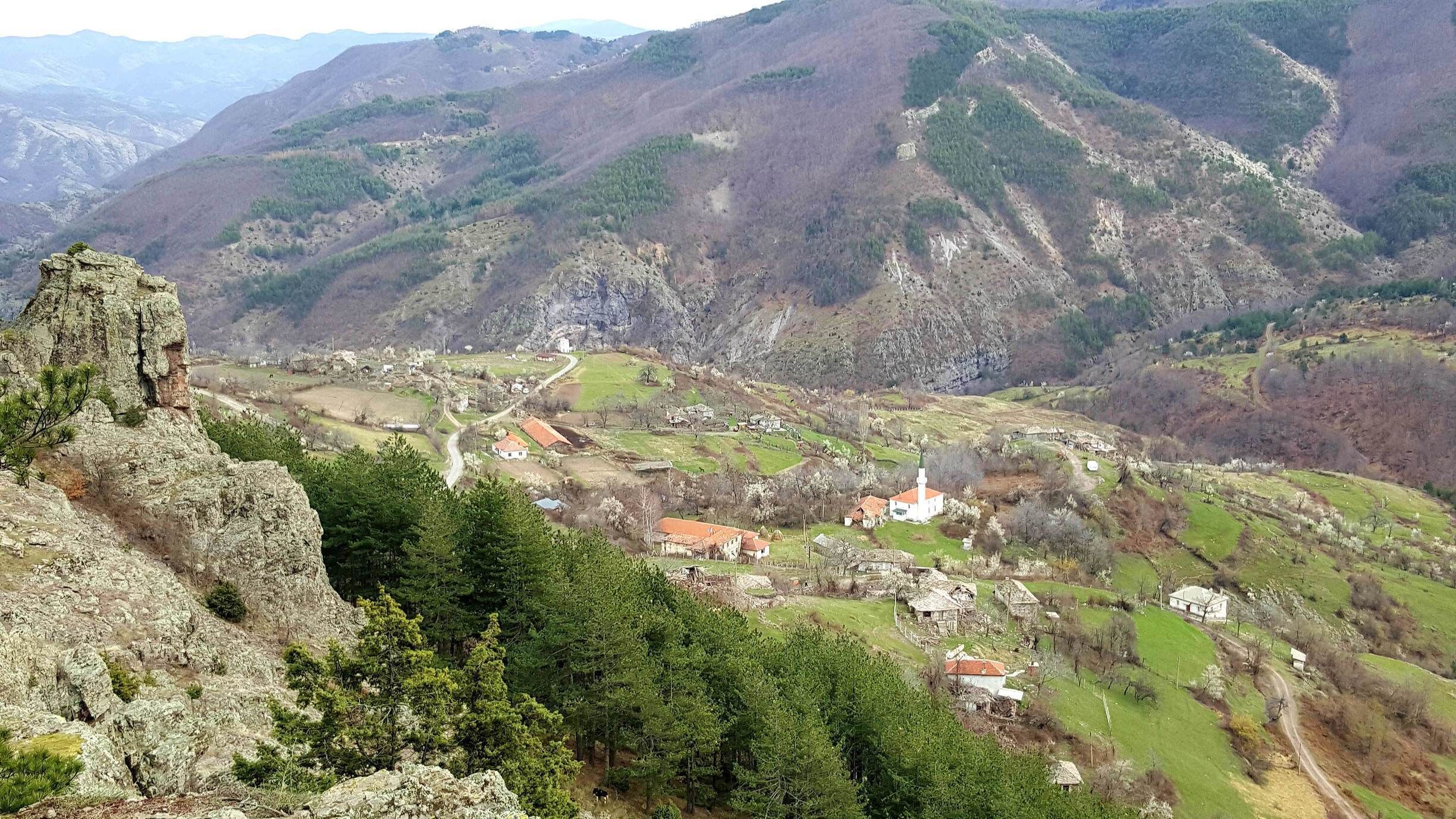 A mountainous landscape with a village nestled in a valley.