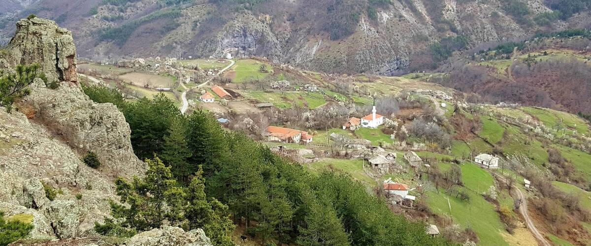A mountainous landscape with a village nestled in a valley.