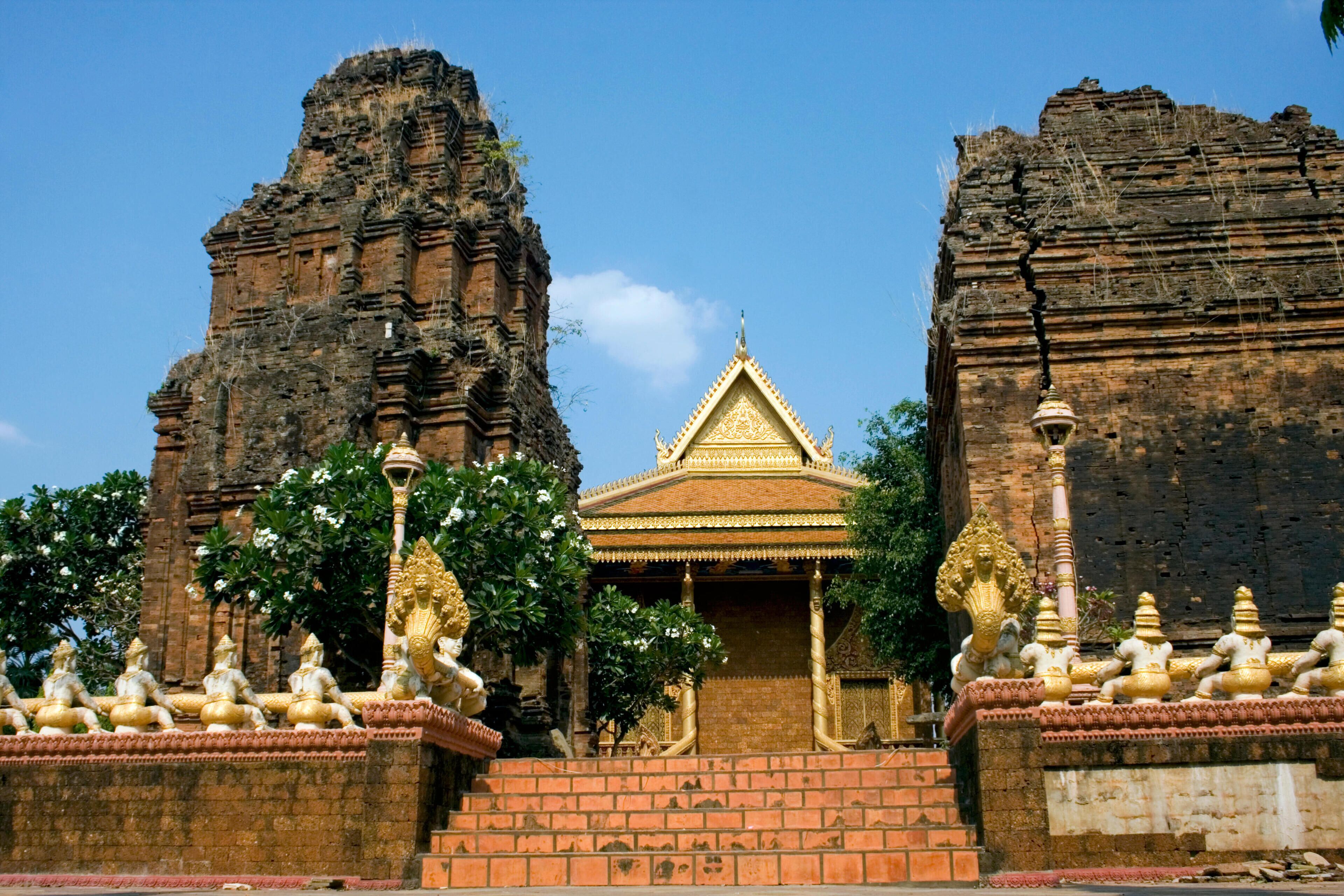 A temple with golden statues, a central shrine, and two large rock structures.