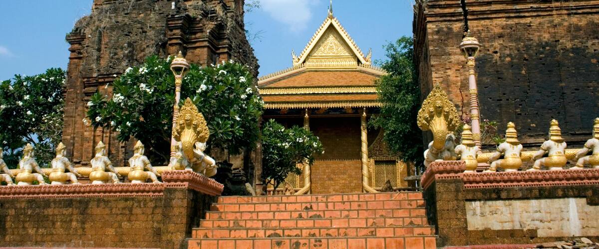 A temple with golden statues, a central shrine, and two large rock structures.