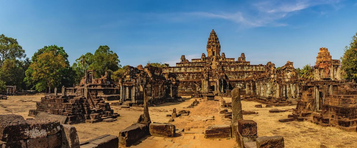 Ancient stone ruins with a large temple structure in the background.