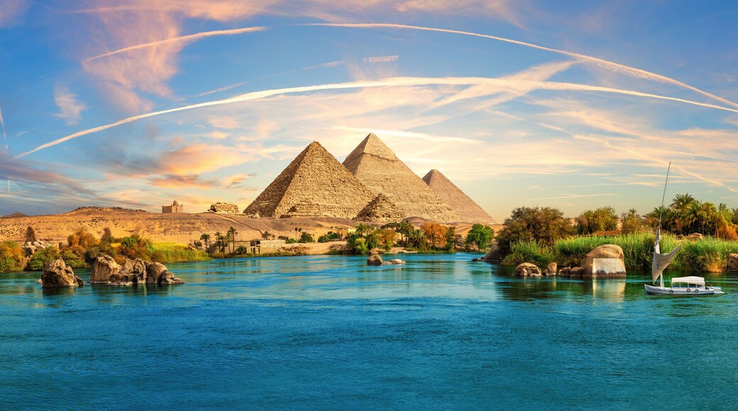 Lonely Saleboat in the Nile river and ancient rocks in the Aswan desert by the pyramids, Egypt