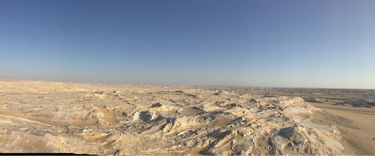 A desert landscape with sand dunes and a clear sky.