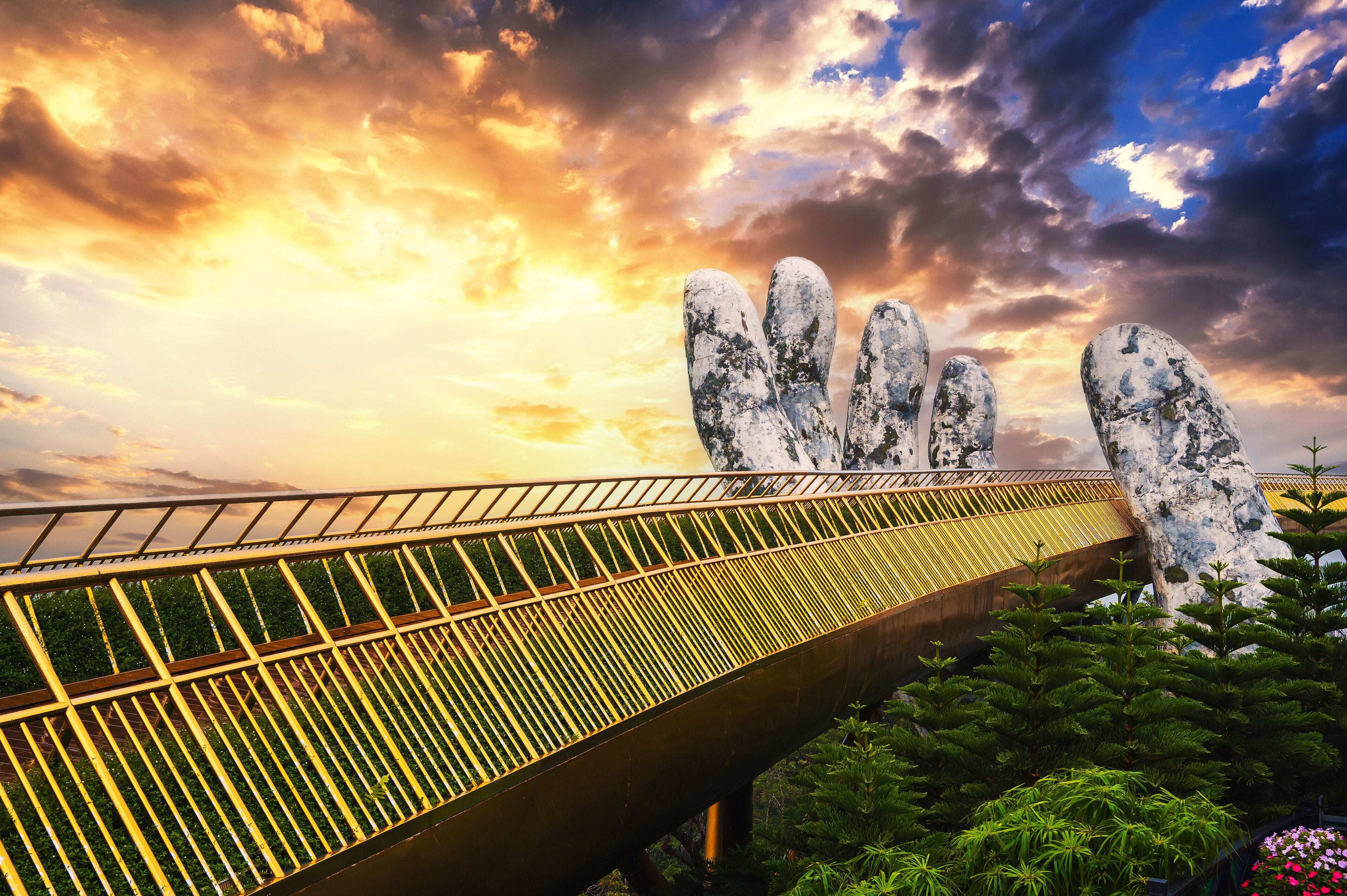 Golden Bridge Hands of God at the Sun World Ba Na Hills park in Da Nang on the mountain at sunset in summer in Vietnam