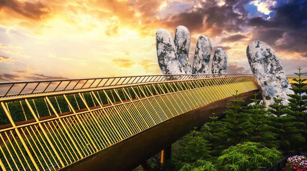 Golden Bridge Hands of God at the Sun World Ba Na Hills park in Da Nang on the mountain at sunset in summer in Vietnam
