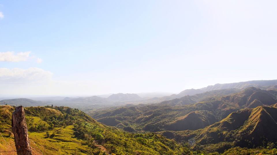 A mountainous landscape with rolling hills and a clear sky.