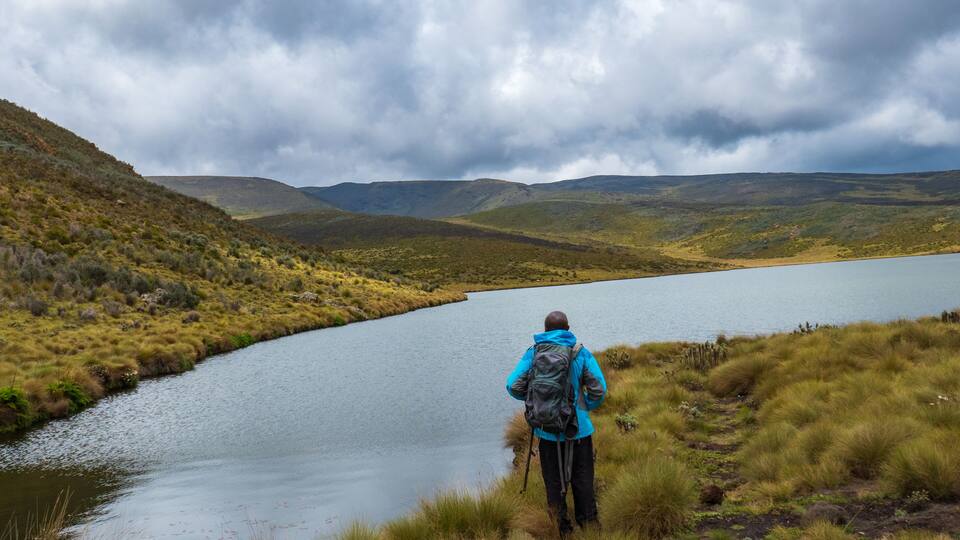 Rear view of a hiker at Lake Ellis, Chogoria Route in Mount Kenya National Park, Kenya