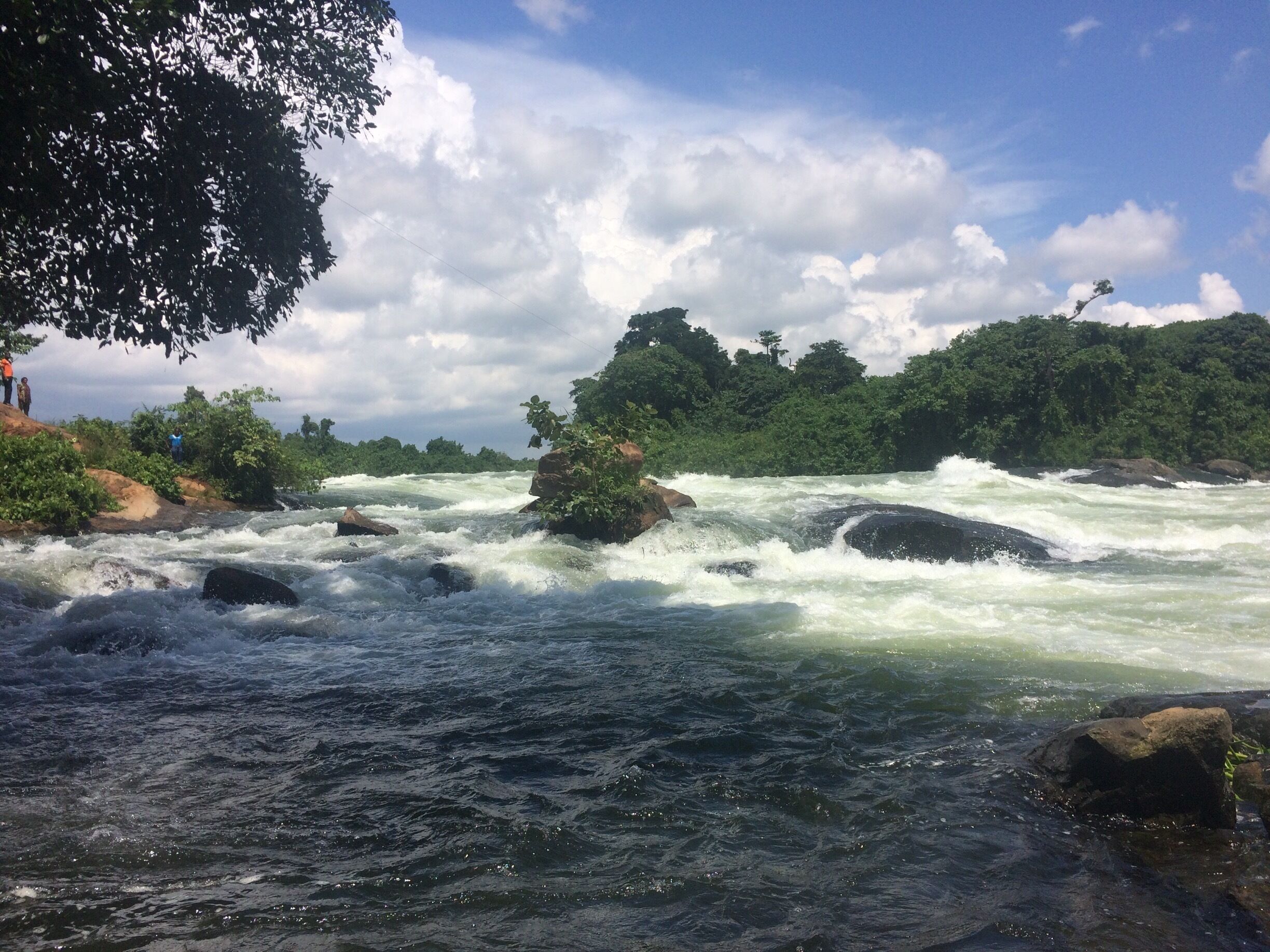 A river with fast-moving water, surrounded by rocks and greenery.