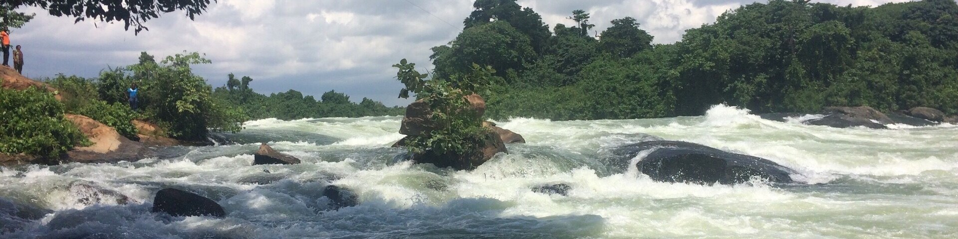 A river with fast-moving water, surrounded by rocks and greenery.