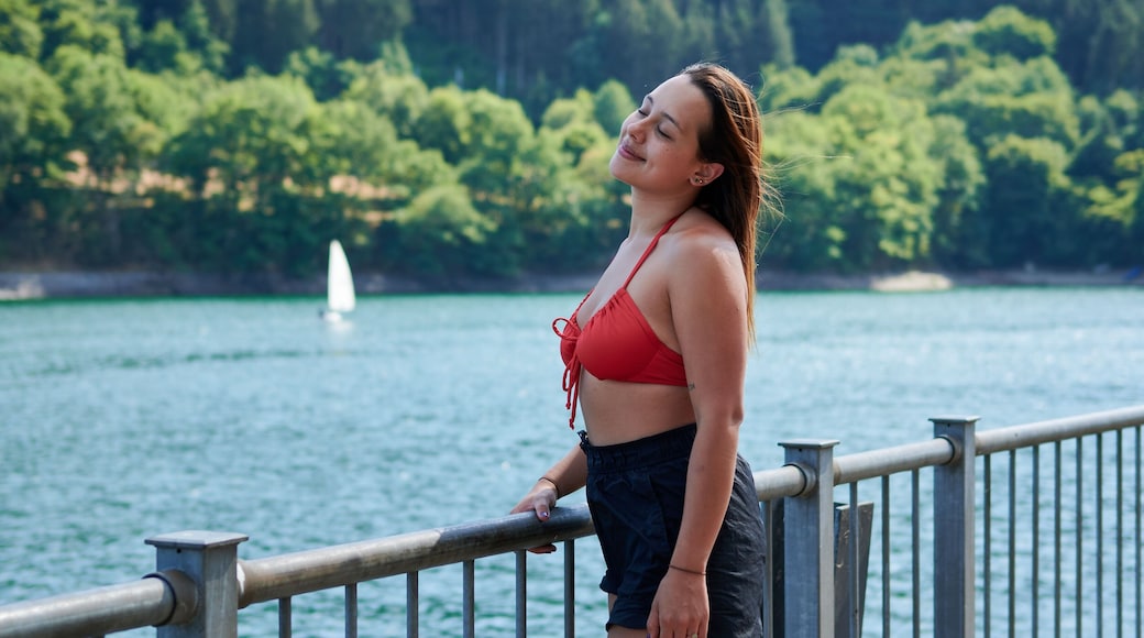 Beautiful young lady smiling with trees in the background in Lac de la Haute-Sure, Luxemburg