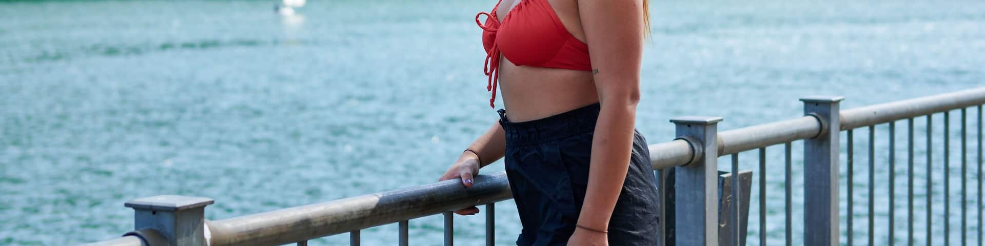 Beautiful young lady smiling with trees in the background in Lac de la Haute-Sure, Luxemburg