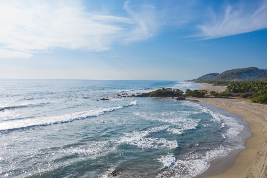 Aerial view of beautiful sandy beach with tranquil waves and serene ocean, Playa Troncones, Mexico.