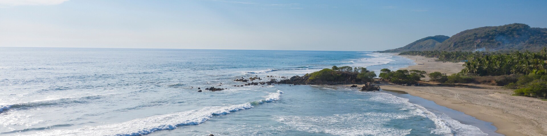 Aerial view of beautiful sandy beach with tranquil waves and serene ocean, Playa Troncones, Mexico.