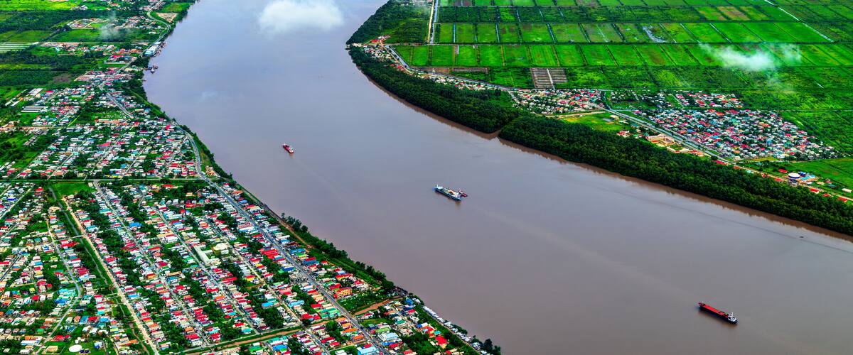 A river winding through a densely populated area with green fields and a small town.