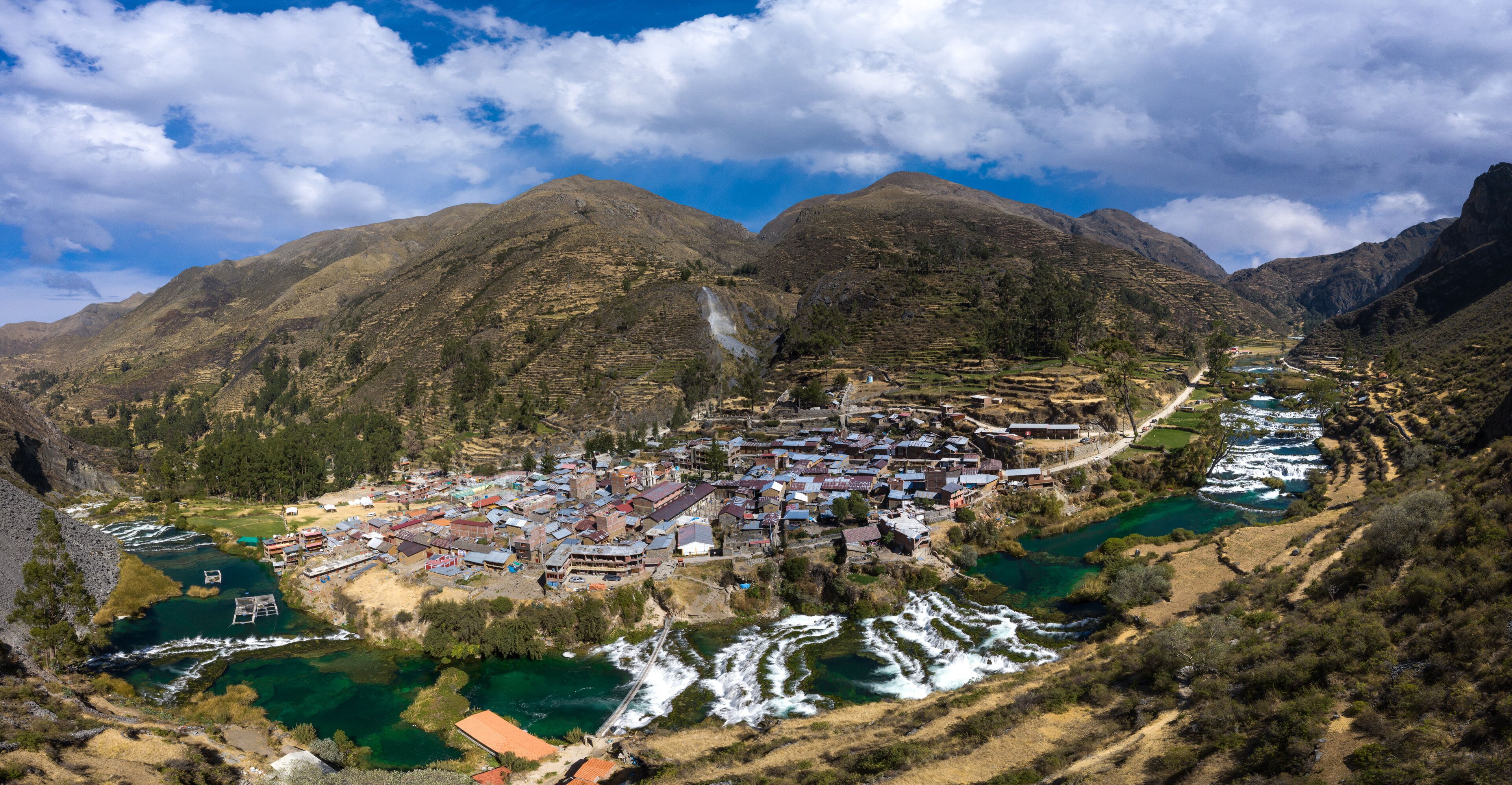 A mountainous town with terraced fields and a river.