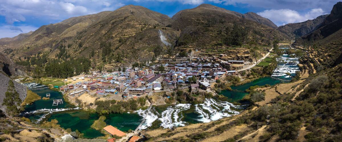A mountainous town with terraced fields and a river.