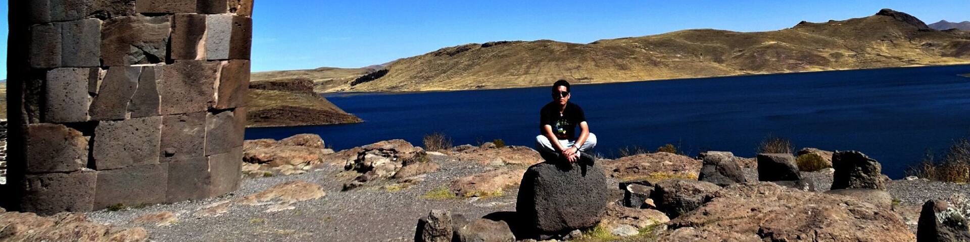 A stone tower by a lake with a clear blue sky.