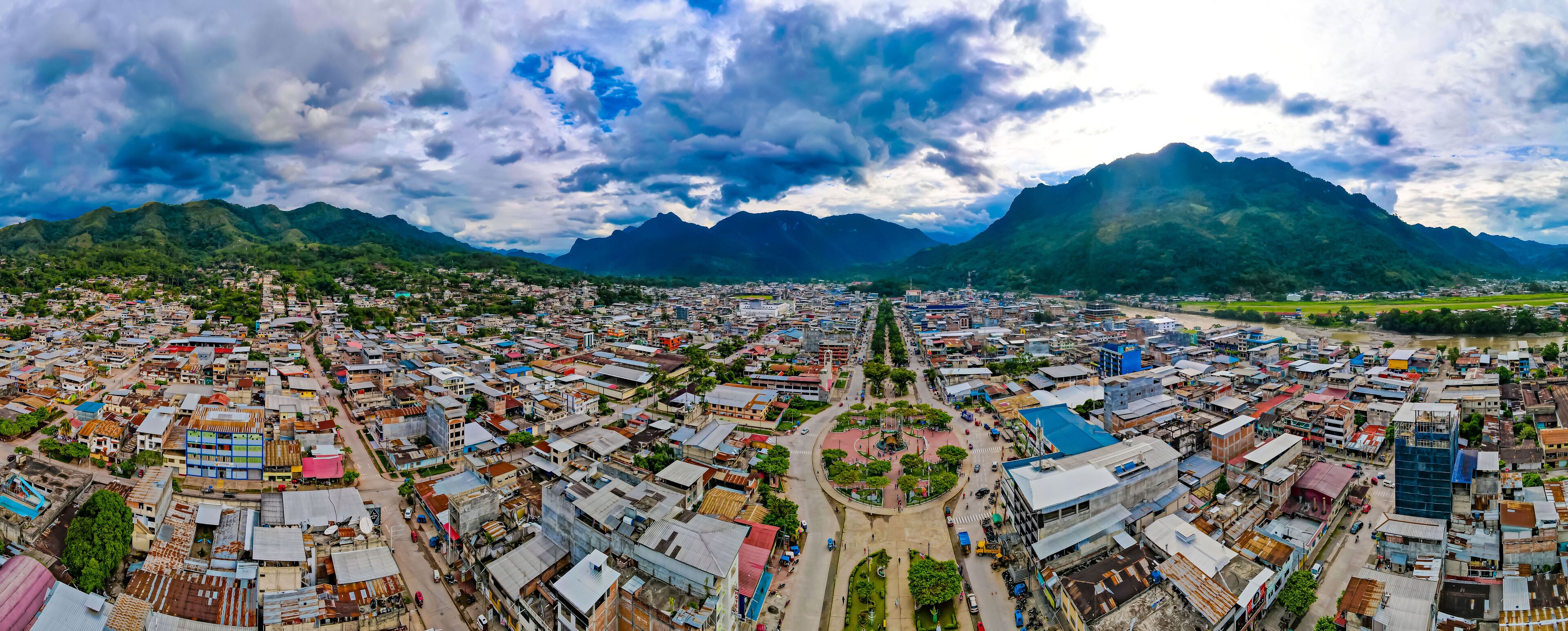 A cityscape with a river, surrounded by mountains.