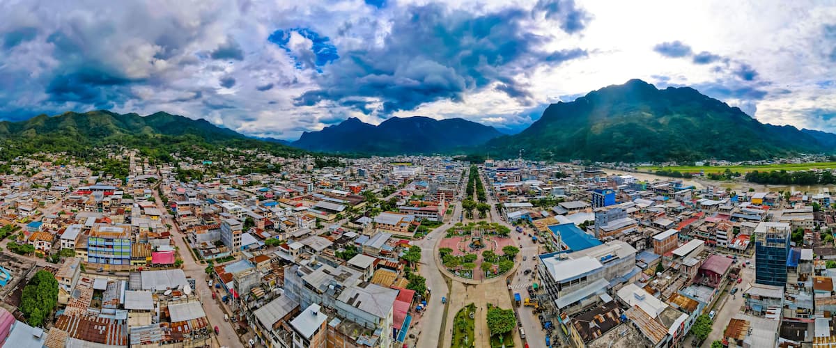 A cityscape with a river, surrounded by mountains.