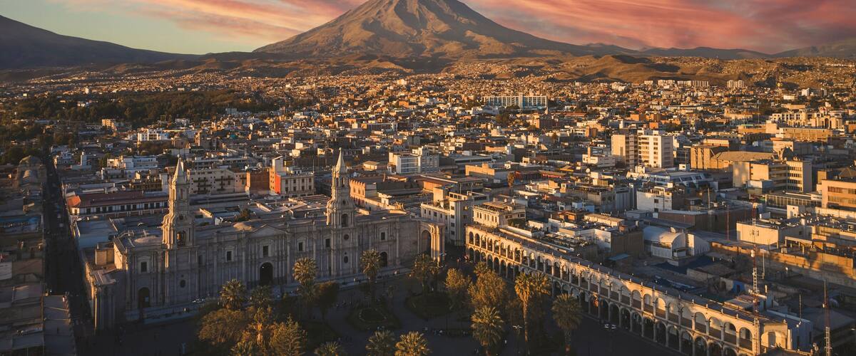 Aerial drone view of Arequipa main square and cathedral church, with the Misti volcano at sunset. Arequipa, Peru.