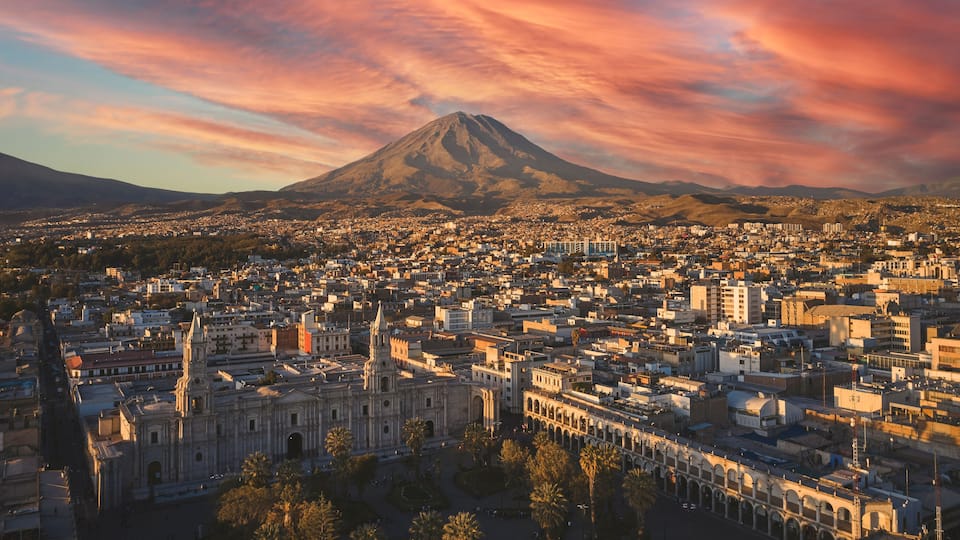 Aerial drone view of Arequipa main square and cathedral church, with the Misti volcano at sunset. Arequipa, Peru.