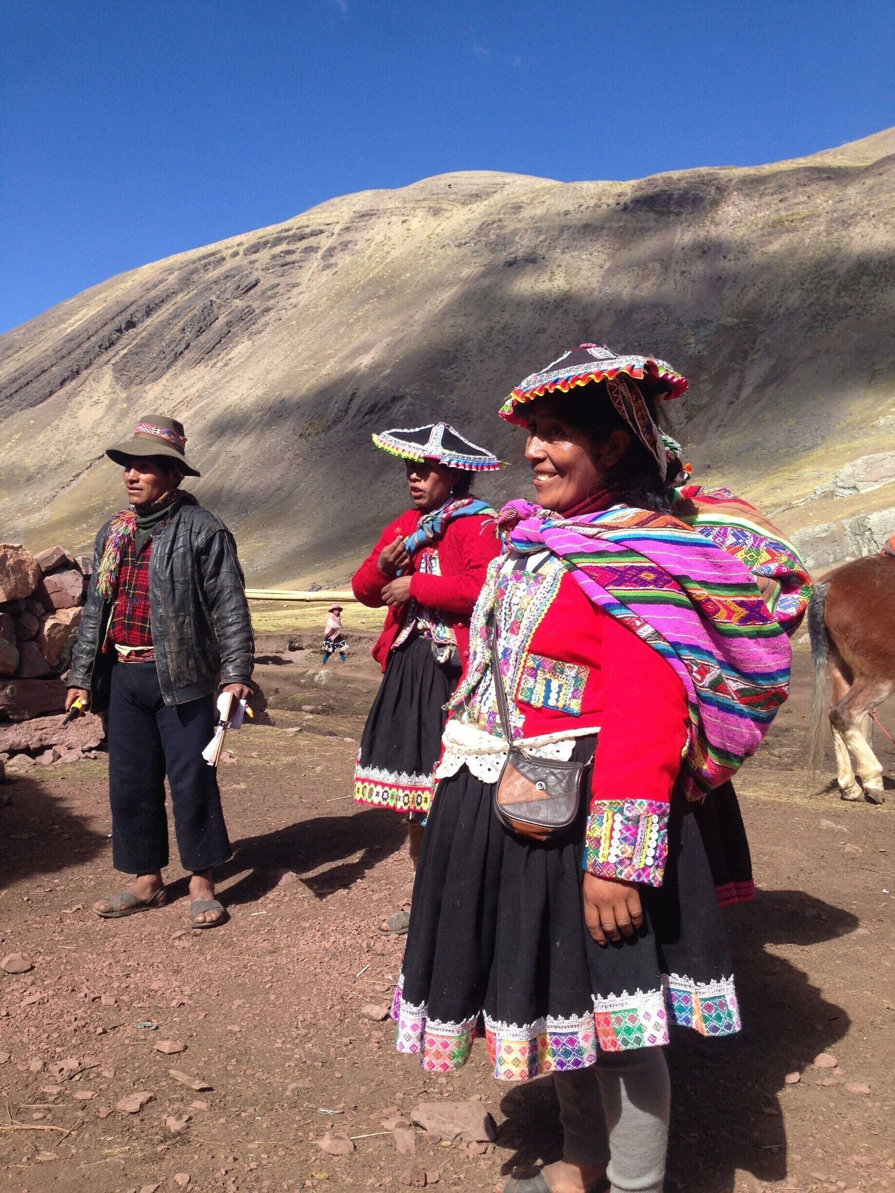A group of people in traditional attire standing in a mountainous area.