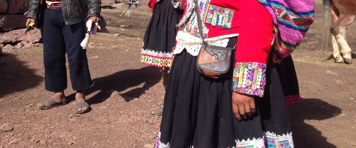 A group of people in traditional attire standing in a mountainous area.