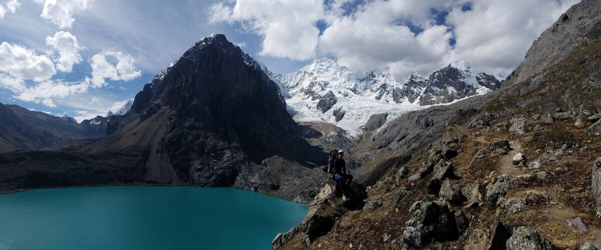 A mountain peak, a turquoise lake, and a hiker.