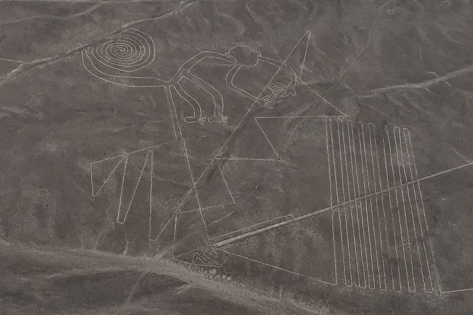 A desert landscape with ancient petroglyphs, including a human figure and geometric shapes.