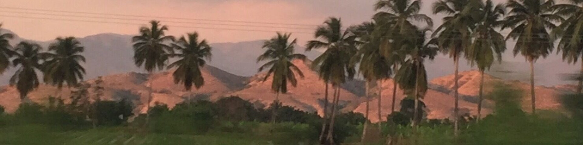 Puesta de sol entre lomas y cocoteros
