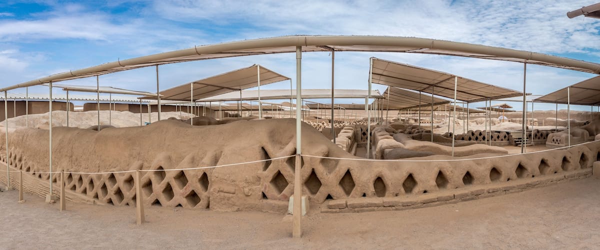 A large open area with multiple covered structures and piles of sand.