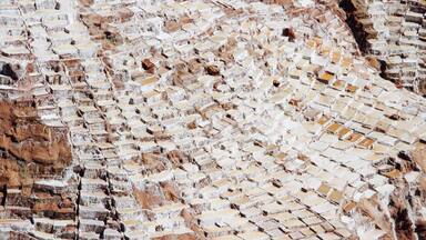 The Salinas Salt Pans in Maras is the most spectacular sight in town of Urubamba. It has been used for salt extraction since Inca times. A hot spring at the top of the valley discharges a small stream to heavily salt- laden water which is diverted into the mountainside pans and evaporated to produce salt. It is beautiful and surreal!