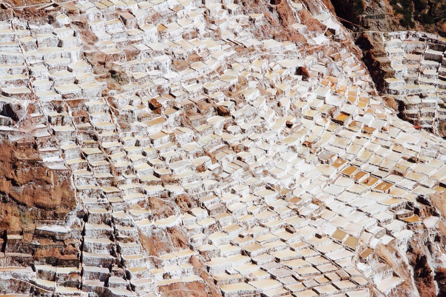 The Salinas Salt Pans in Maras is the most spectacular sight in town of Urubamba. It has been used for salt extraction since Inca times. A hot spring at the top of the valley discharges a small stream to heavily salt- laden water which is diverted into the mountainside pans and evaporated to produce salt. It is beautiful and surreal!