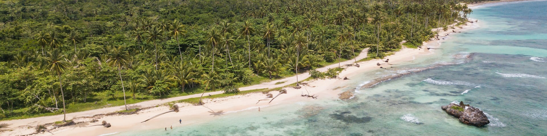 View of the ocean coast beach and mountains. Secluded white sand beach and mountains. Summertime Sea tranquility. Aerial view