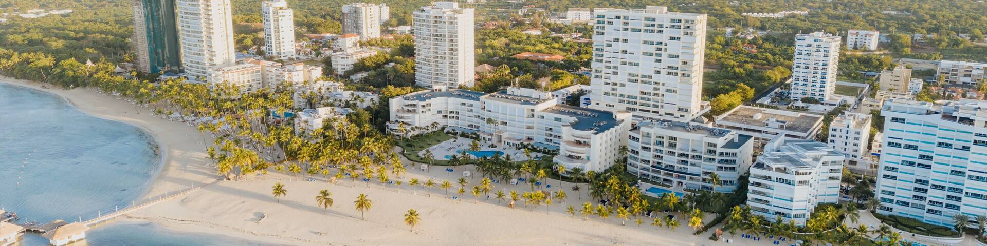 Aerial view of the coastal resort area of Juan Dolio, featuring high-rise buildings, sandy beaches, palm trees, and turquoise waters in Juan Dolio, San Pedro de Macoris, Dominican Republic.