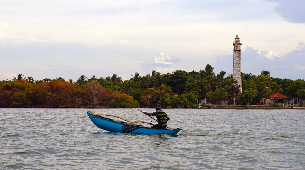 Fisherman on Batticaloa Lagoon with a colonial-era lighthouse in the background